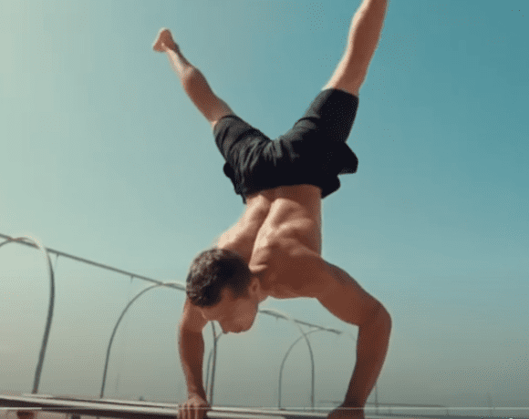 Calisthenics exercise - man performing a handstand at home with no equipment.