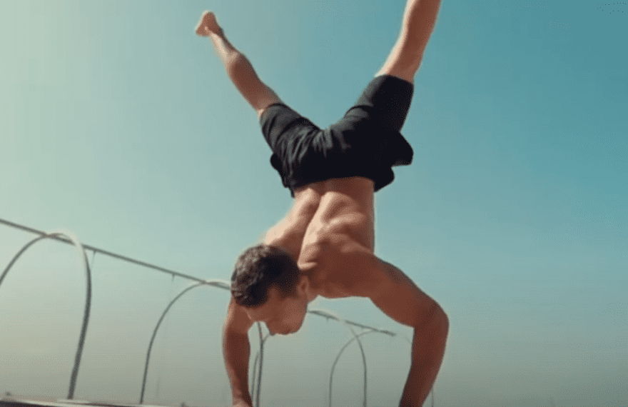 Calisthenics exercise - man performing a handstand at home with no equipment.