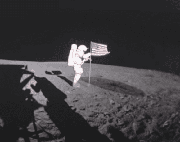 Astronaut planting American flag on the moon's surface during the Apollo 11 mission, image used in Moon Landing Hoax conspiracy theory article.