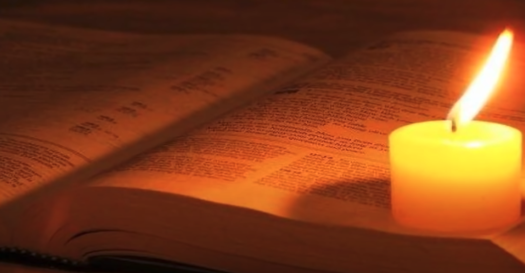 Opened Bible and candle