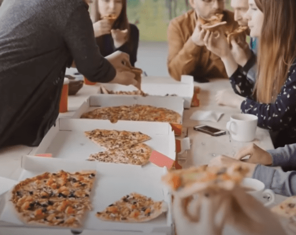 people eating pizza on a table