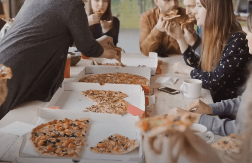 people eating pizza on a table