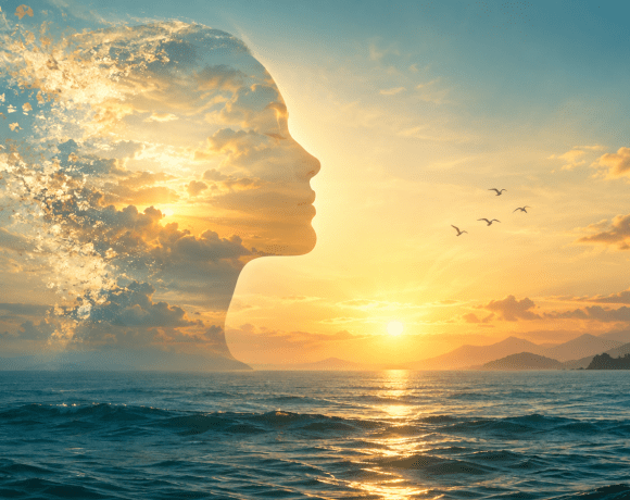 Conceptual human profile blending into golden light above a calm sea