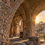 Illustration of ancient Roman concrete arches and exposed stone aggregate in warm sunlight.