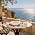 AI-assisted conceptual illustration of an empty seaside café table with a notebook and glass of water.