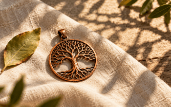 Conceptual copper tree pendant on linen with a leaf and branching shadows